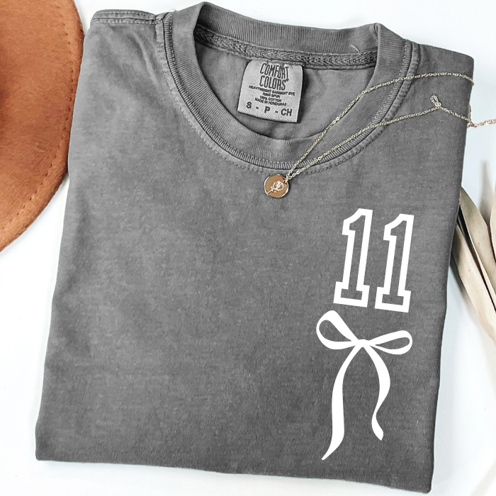 Gray Comfort Colors 11 birthday shirt with minimalist coquette bow design for girls