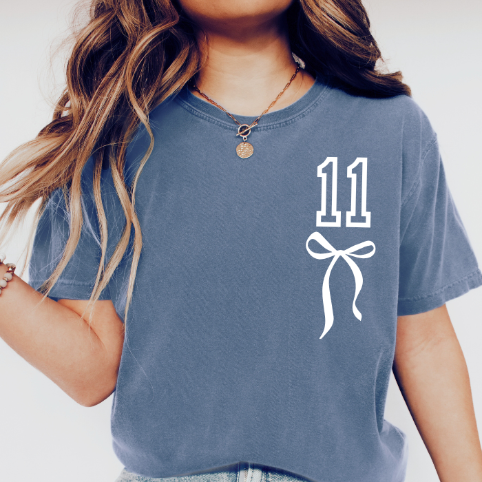 Female Girl woman wearing blue Comfort Colors 11 birthday shirt with white coquette bow design