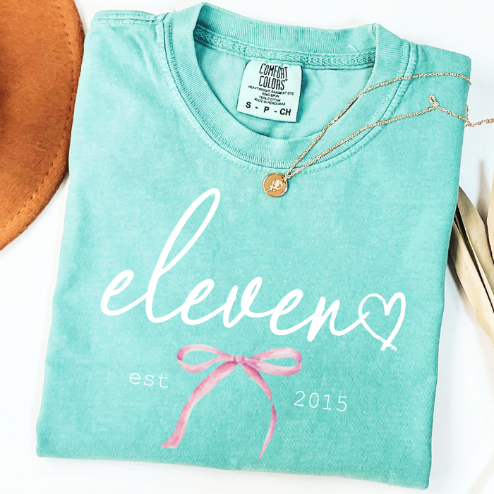 Mint green Comfort Colors 11th birthday tee for girls with feminine eleven lettering and soft boutique aesthetic