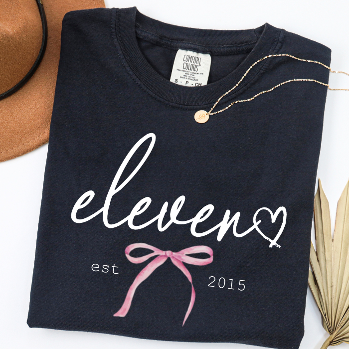 Black Comfort Colors 11th birthday shirt featuring white eleven script design, perfect birthday gift for girls