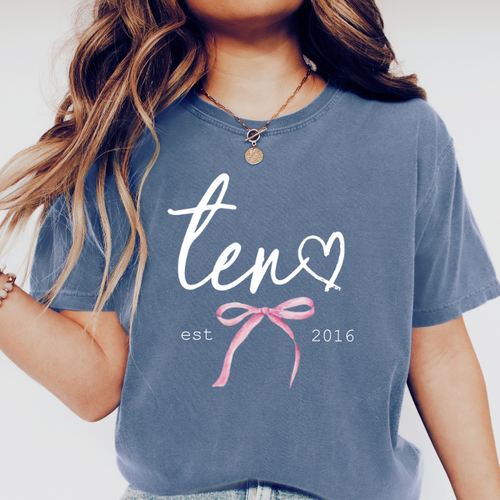Girl wearing blue Comfort Colors eleven birthday shirt with feminine script design for an 10th birthday celebration