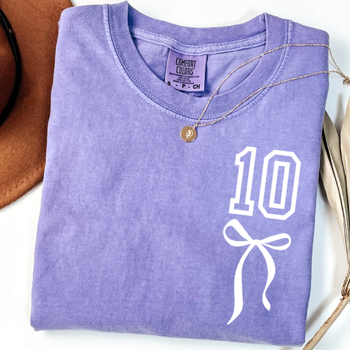 Lavender Comfort Colors 10th birthday shirt for girls featuring white number 10 with coquette bow design