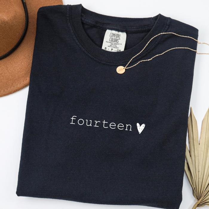 black comfort colors shirt that says fourteen with a chalk heart
